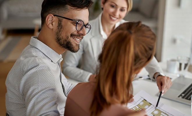 Homebuyers Reviewing Floorplans With Sales Agent